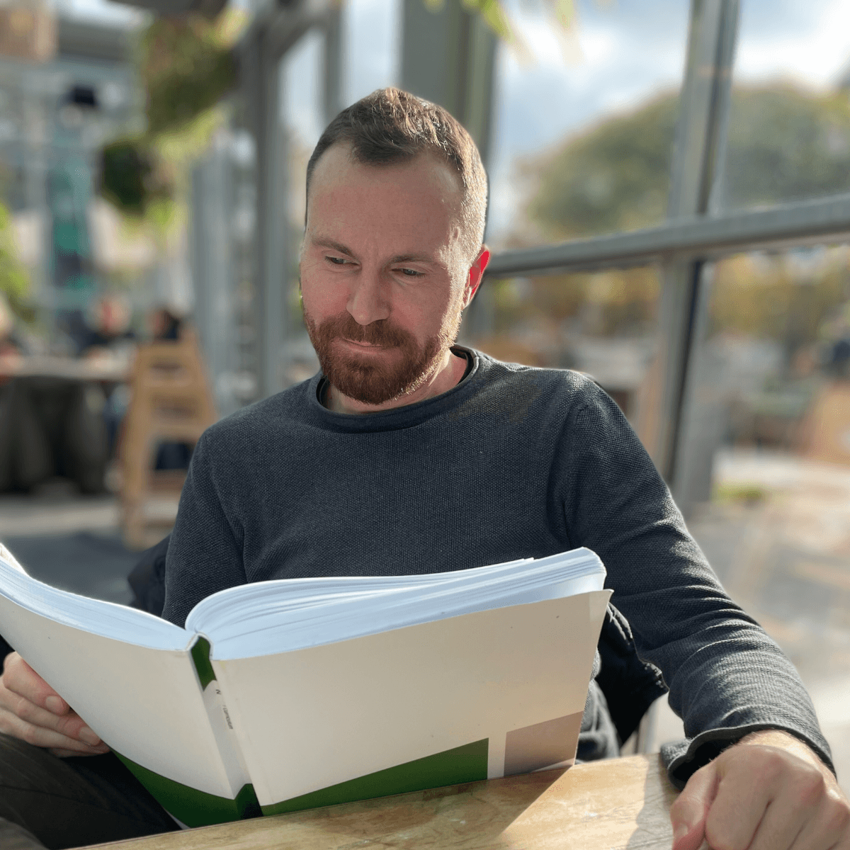Marc Hoppermann reading in a café